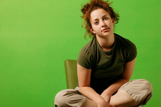 Teenage girl sits in a chair