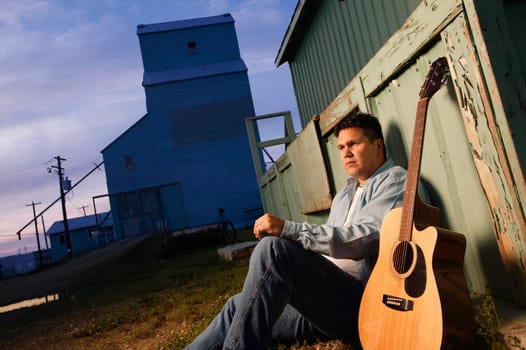 Man sits beside guitar