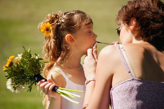 Flower girl getting lipstick