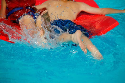 Two children splash in the pool