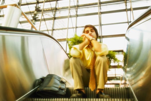 Man sits on an escalator