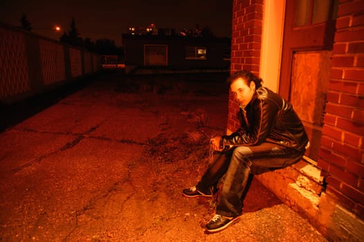 Man sits under street light