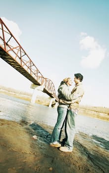Couple embrace in river valley