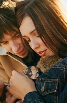 Couple cuddle a kitten