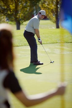 Woman holds flag on putting green