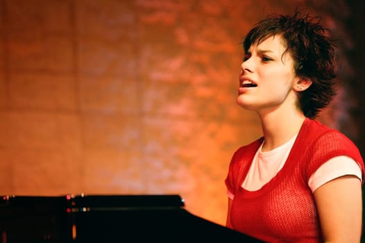 Woman plays the piano and sings