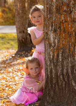 Two little fairy girls in the Autumn forest