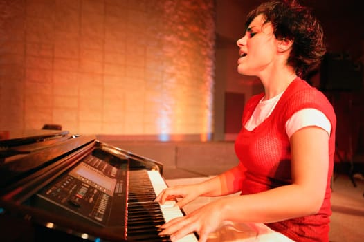 Woman plays the piano and sings