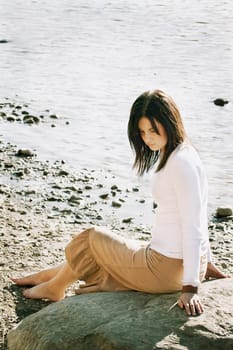 Woman sits on beach