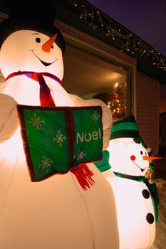 Snowman Family and Christmas decorations outside Home