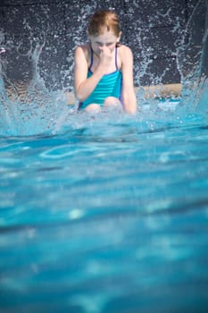 Girl splashes in swimming pool