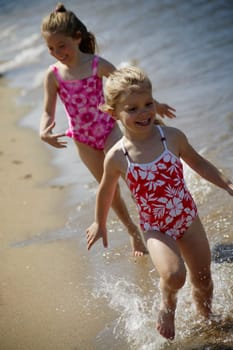 Two children running along the beach