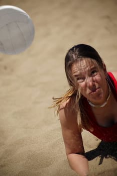 A woman plays beach volleyball