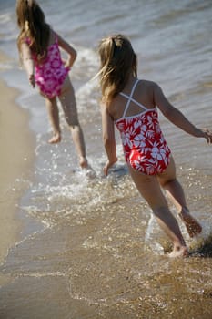 Two children running along the beach