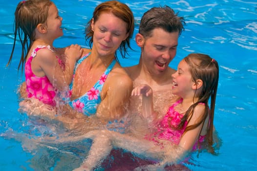 Family having fun in swimming pool