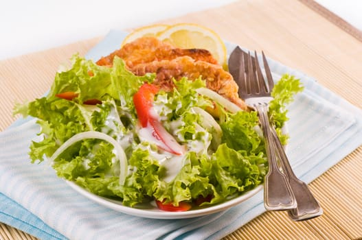 Lettuce with fried mullet fillet served in a white salad bowl