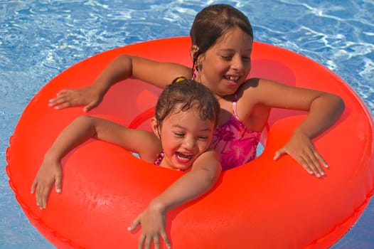 Two girls with rubber ring in pool