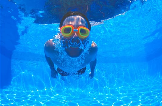 Boy with goggles in swimming pool