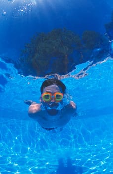 Boy with goggles in swimming pool