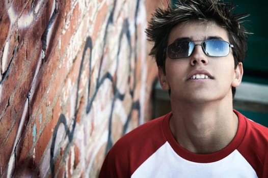 A teen by a wall of graffiti