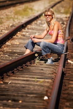 Woman sitting on train tracks