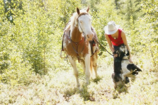 Cowgirl with horse and dog