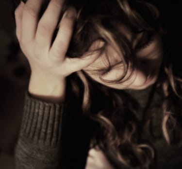 Woman holding head in hand