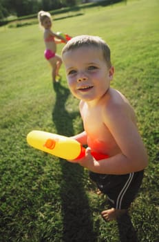 Children playing in the park with water pistols