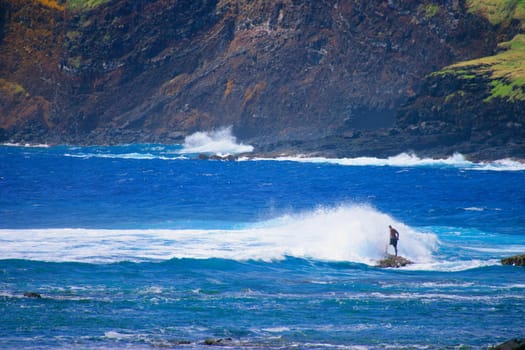 Man standing as wave hits him