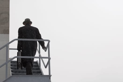 Man climbing outside stairs in cold weather