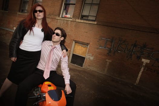 Trendy couple posing on a scooter