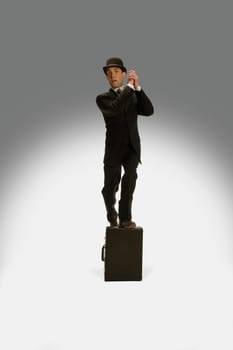 A winning businessman stands on his briefcase