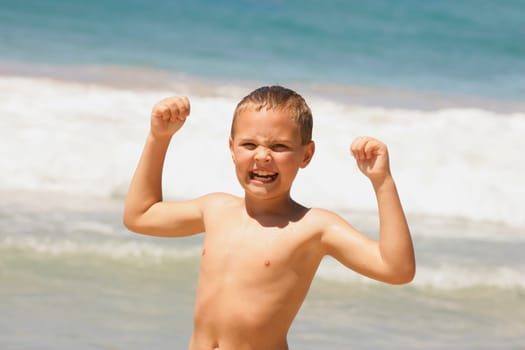 Young boy showing off muscles