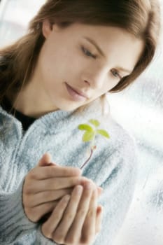 Young woman with new plant