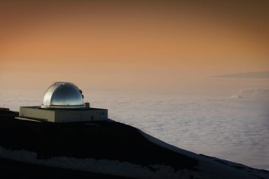 Hawaiian telescope looking over clouded landscape below