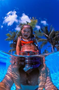 Father and daughter playing in the pool