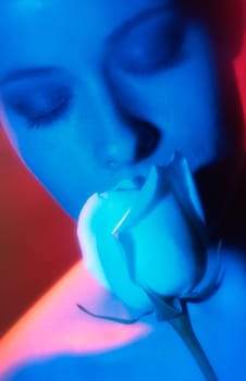 Young woman smelling a rose