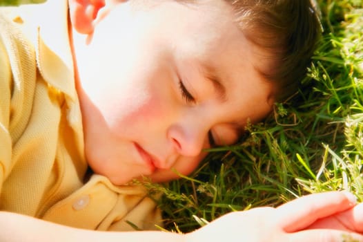 Little boy asleep on the grass
