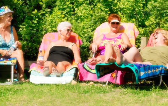 Group of four women sun tanning