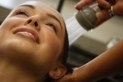 A woman getting her hair rinsed at a salon