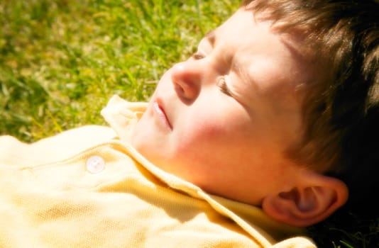 A young boy lying in the sun