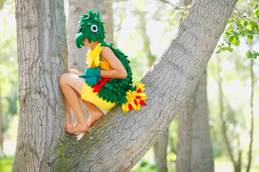 A child in bird costume up in a tree
