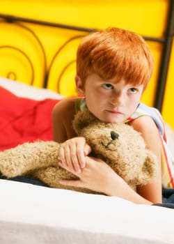Young super hero holding teddy bear