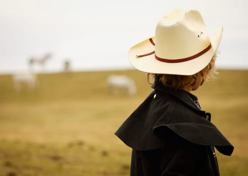 Young cowboy in field
