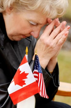 Woman praying over flags from different countries
