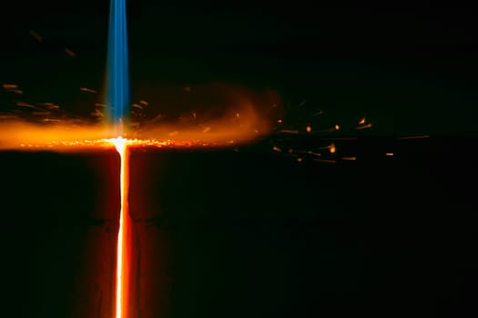 Closeup of flame cutting a bar of steel