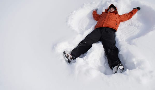 Boy making snow angel