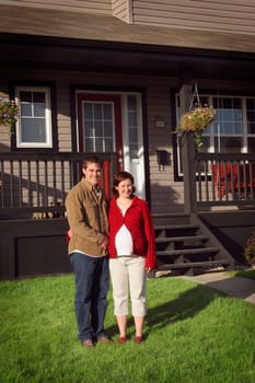 Couple standing in front of new home