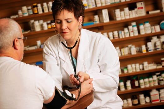 Doctor takes an older patients' blood pressure