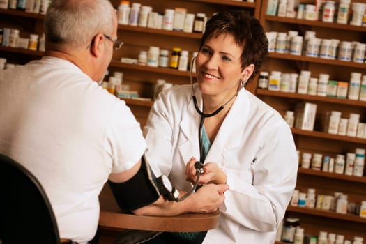 Pharmacist taking patient' s blood pressure